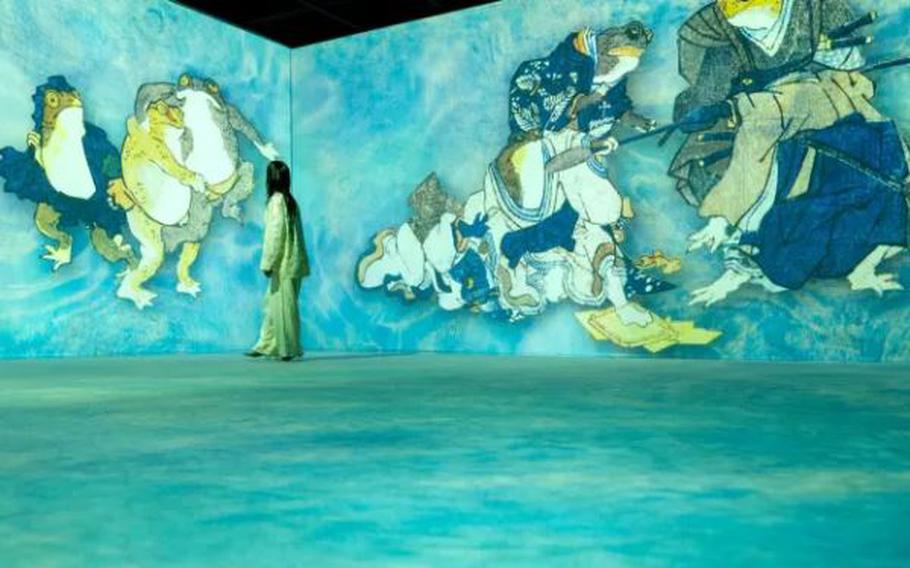 A woman looking at the immersive ukiyo-e art on the wall.